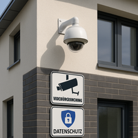 Moderne Hausfassade mit einer Überwachungskamera und Hinweisschildern für Videoüberwachung und Daten
